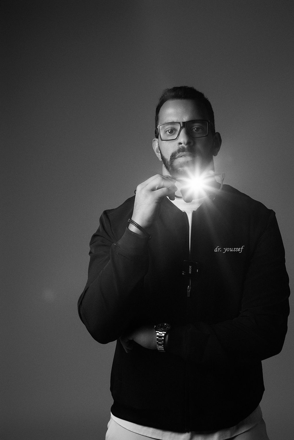 My Dental Hub artistic black and white portrait of a male dentist adjusting his glasses in Skokie, IL