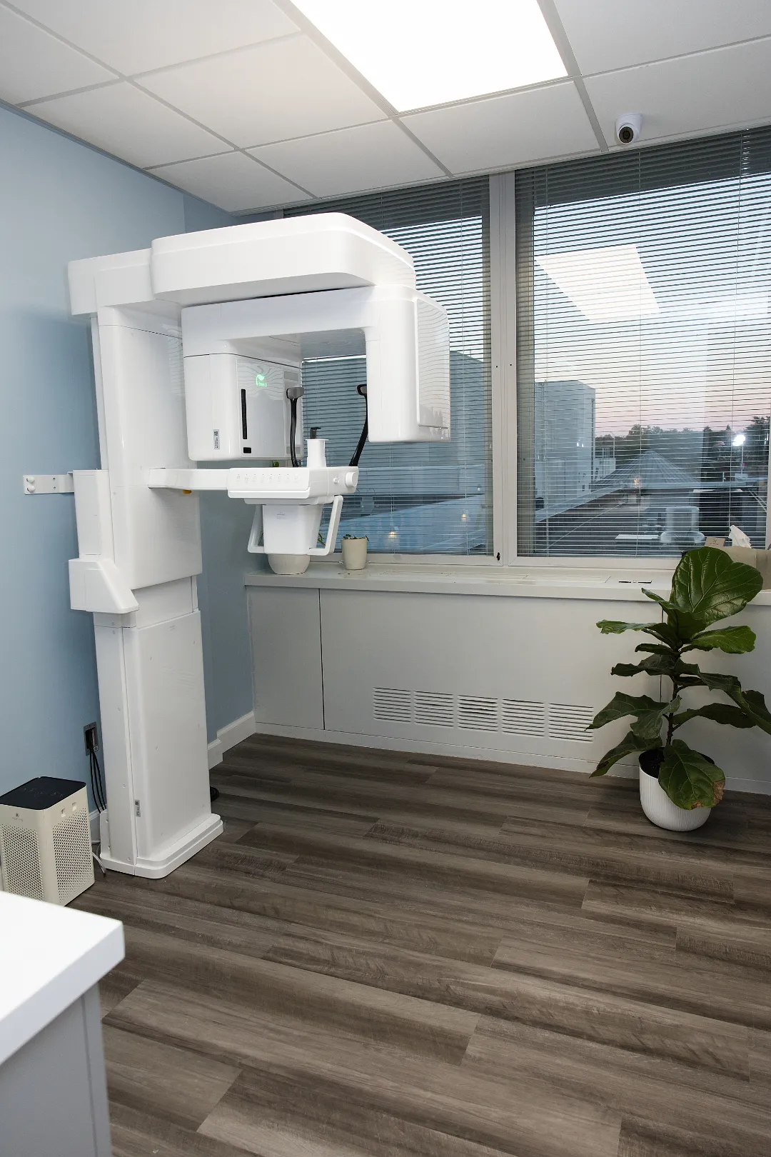 White freestanding CBCT imaging machine next to a window with a potted plant — My Dental Hub in Skokie, IL