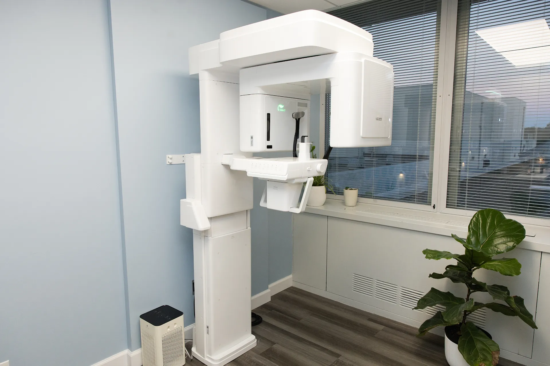 White CBCT scanner machine with rotating C-arm next to a window in a dental clinic — My Dental Hub in Skokie, IL