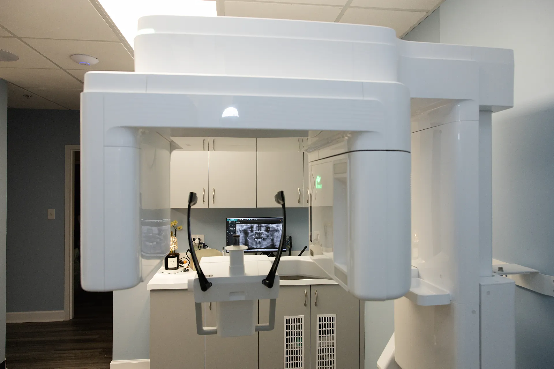White dental imaging machine with rotating arm and chin rest in an exam room — My Dental Hub in Skokie, IL