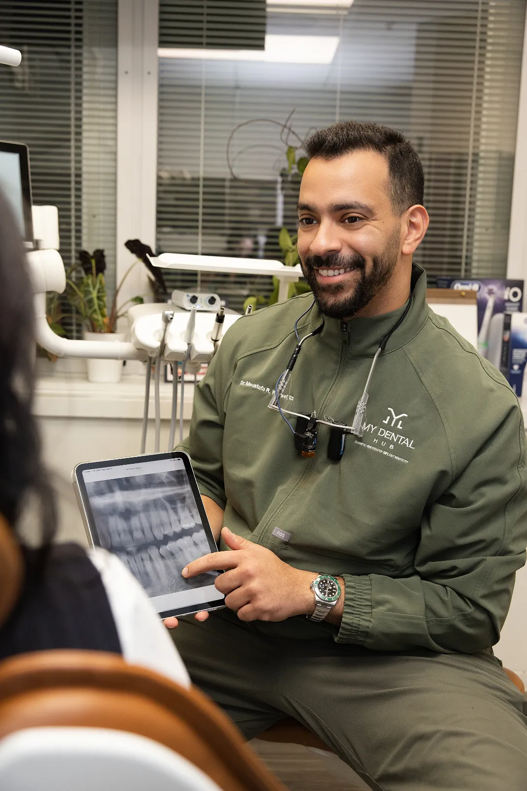 Dentist pointing to an X-ray on a tablet while talking with a patient — Skokie, IL