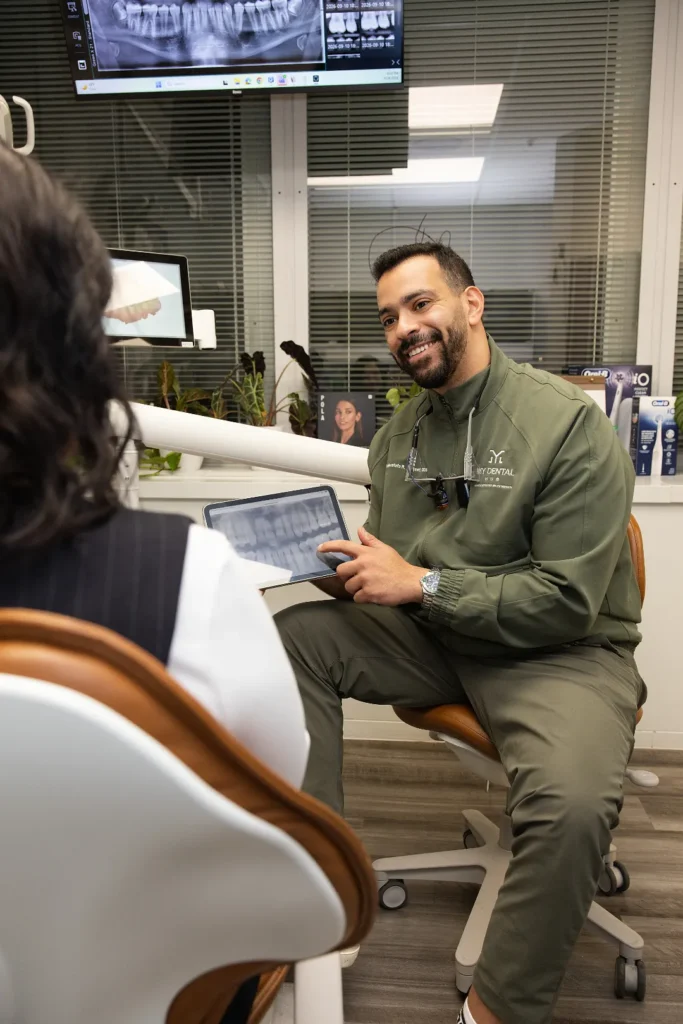 Dentist pointing at a digital x-ray on a tablet while discussing treatment with a patient in an operatory — My Dental Hub in Skokie, IL