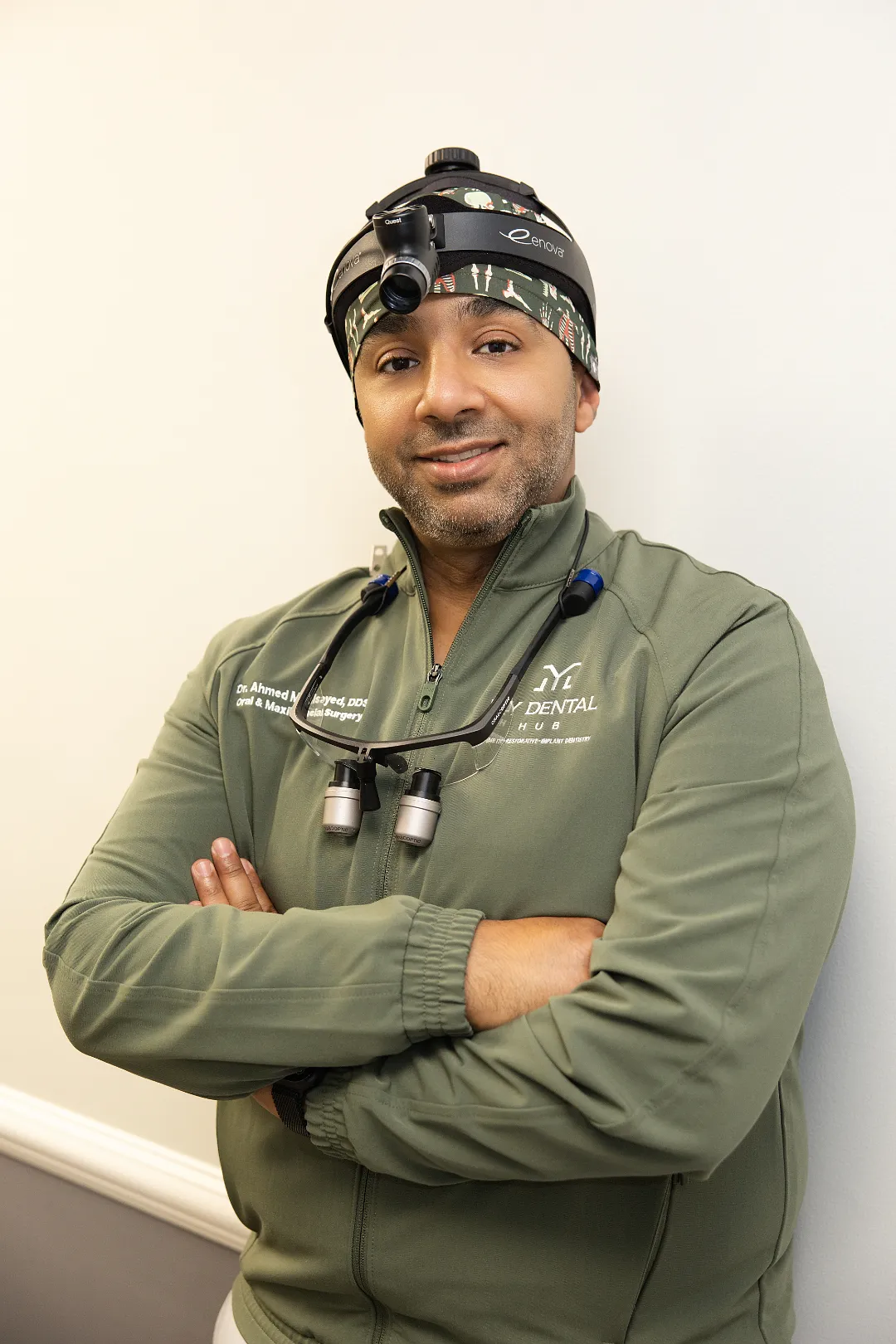 Dentist wearing surgical loupes and headlamp with arms crossed — Skokie, IL